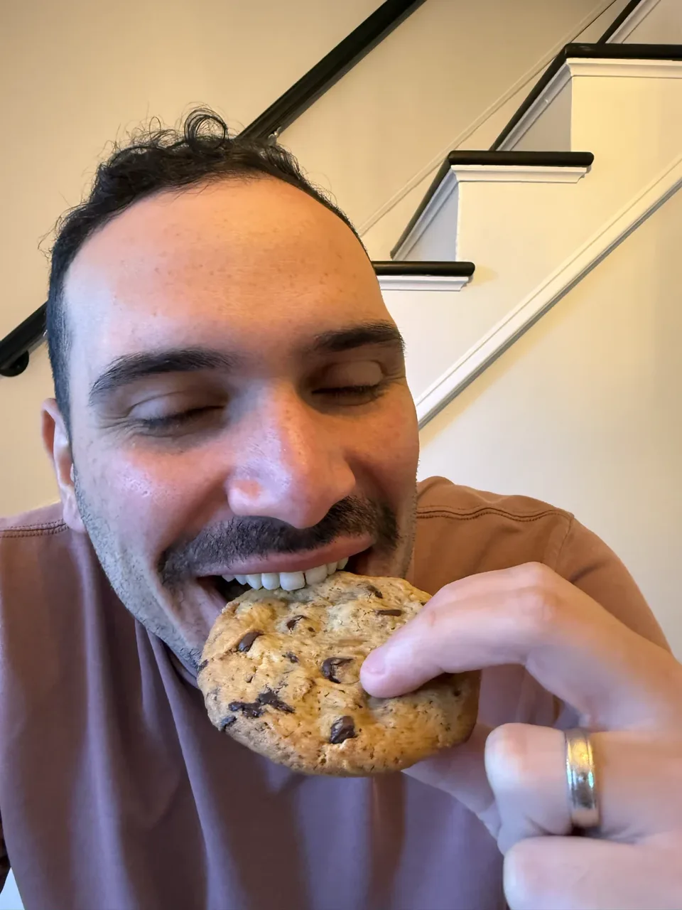 Taking a bite of a chocolate chunk cookie.